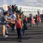 Veterans receiving a warm welcome with American flags, symbolizing the support provided by organizations like Vehicles for Veterans