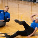 A female service member participates in a volleyball game during the Warrior Care program training, highlighting adaptive sports as part of veteran rehabilitation.