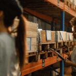 Woman in a warehouse environment, smiling and working, representing career growth and the Amazon Career Choice program