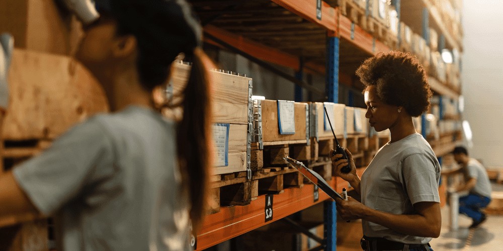 Woman in a warehouse environment, smiling and working, representing career growth and the Amazon Career Choice program