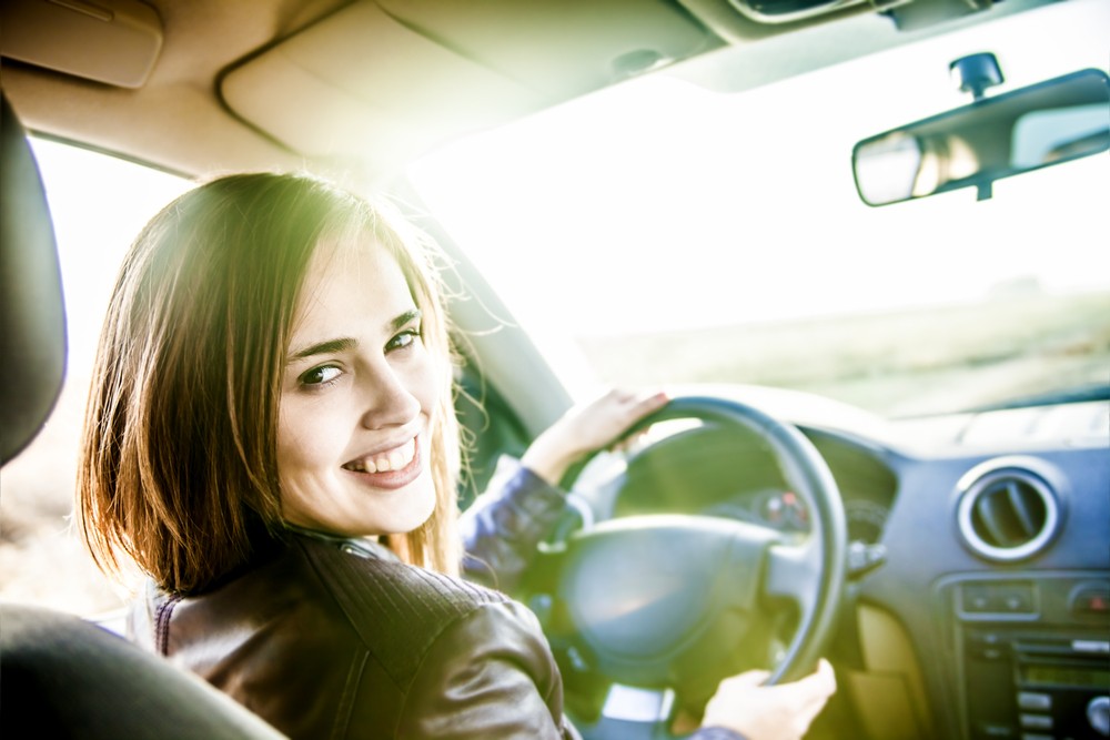 Smiling woman in car, representing free cars for single moms.