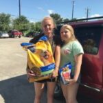 Family with dog receiving pet food assistance