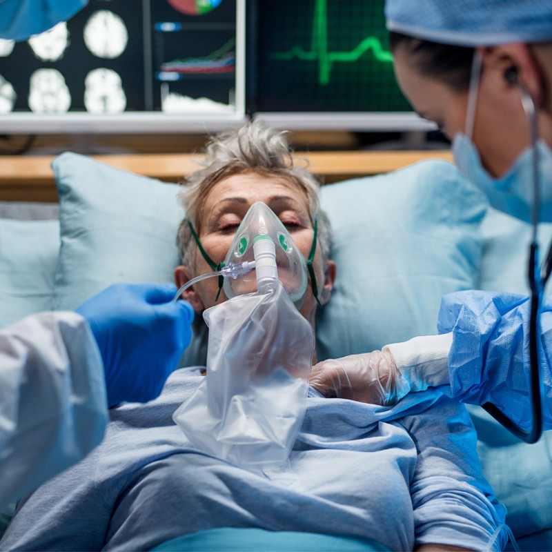 An acute care nurse practitioner tending to a patient in a hospital setting. Learn about acute care nurse practitioner certification programs online to advance your nursing career.