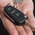 Ford car key fob and key in hand for programming a remote