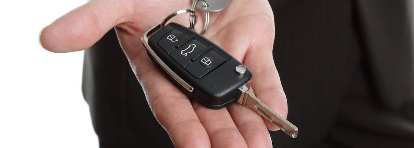 Ford car key fob and key in hand for programming a remote