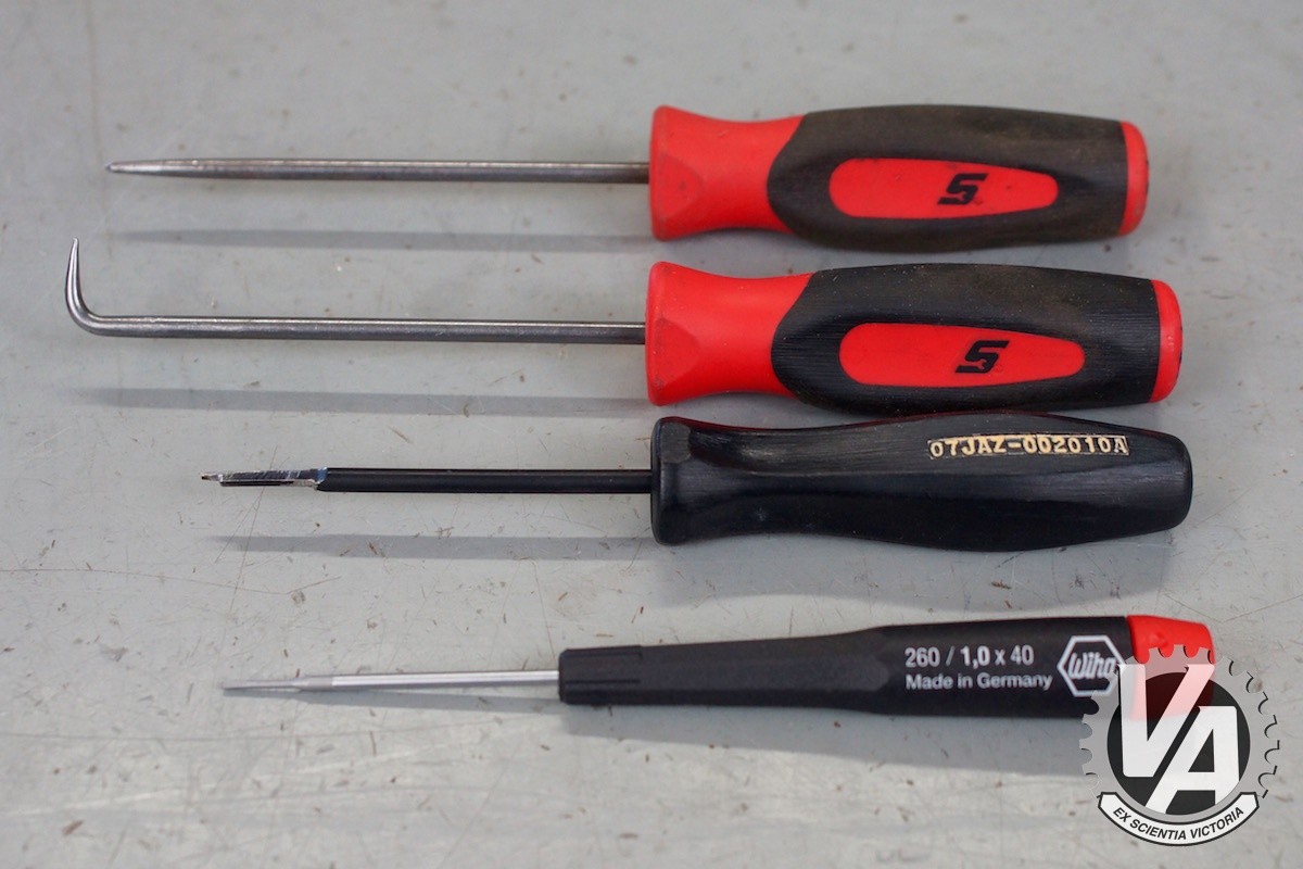 The essential tools for ECU pin removal: straight and right-angle pick tools, Honda ECU pin removal tool, and a precision slot screwdriver.