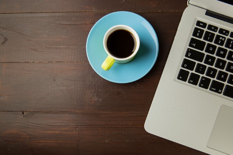 Coffee and laptop in a cafe, representing the start of a new career in programming