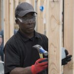 Man working on car engine with diagnostic tool